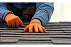 Residential roof repair technician replacing shingles after storm